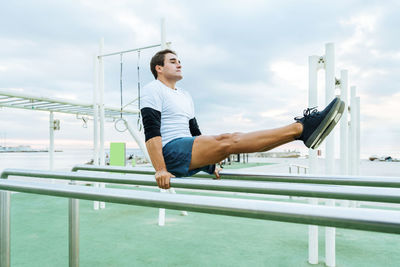 Side view of young woman exercising in gym