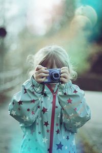 Close-up of girl photographing with camera outdoors