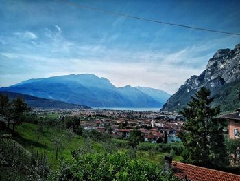 Scenic view of townscape by mountains against sky