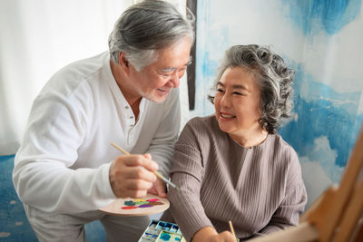 Smiling senior couple painting