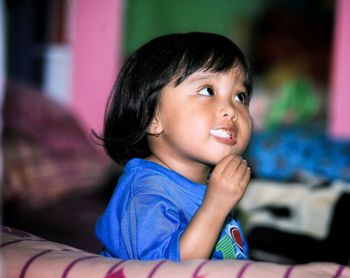 Portrait of cute boy looking away at home
