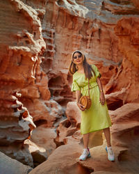 Portrait of woman standing against rock formations