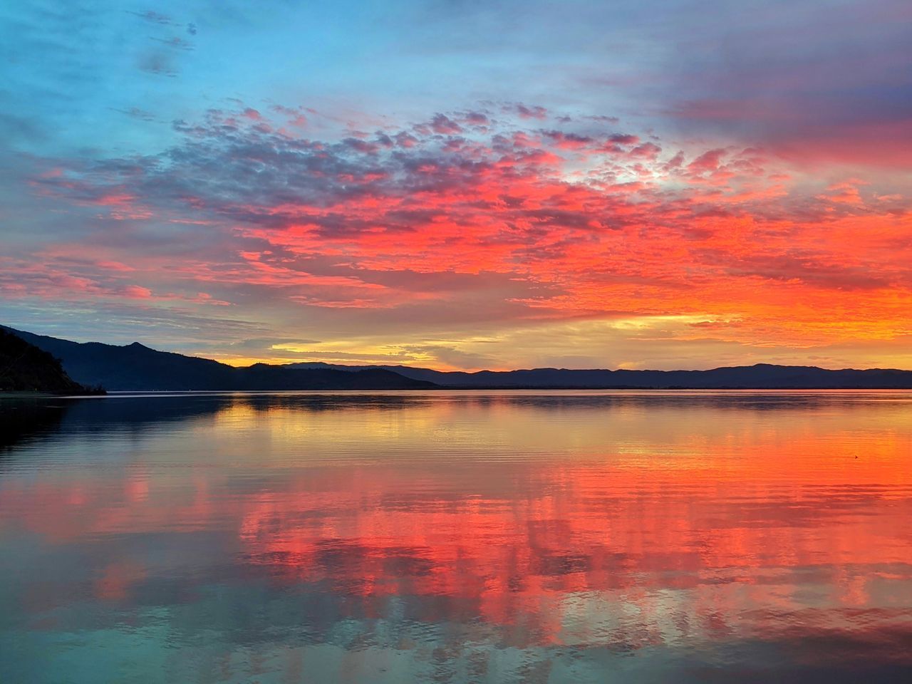 SCENIC VIEW OF LAKE AGAINST ORANGE SKY