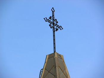 Low angle view of weather vane against clear blue sky