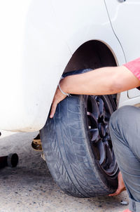 Midsection of man repairing car wheel