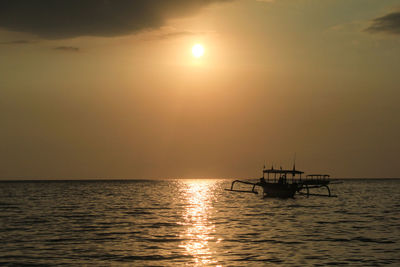 Silhouette boat in sea against sky during sunset