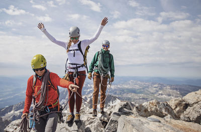 Three rock climbers celebrate reaching summit of grand teton, wyoming