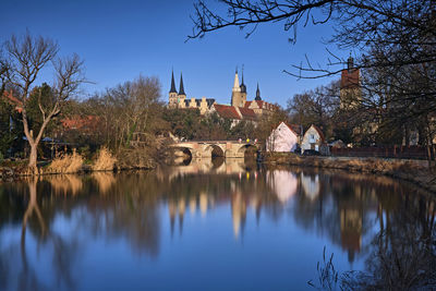 Scenic view of lake by buildings against sky