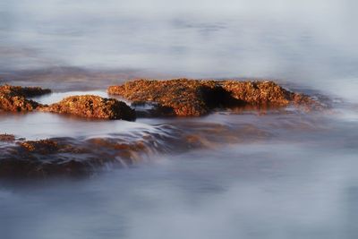 Scenic view of rocks in sea against sky