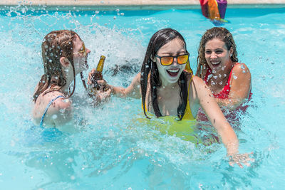 A group of young women from different ethnic groups playing splash around in a pool