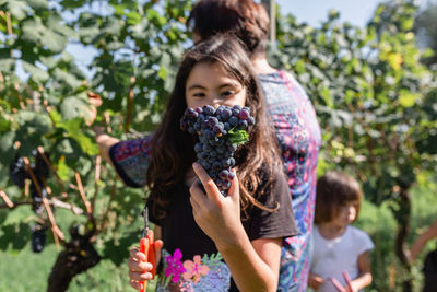 Close up of grapes a girl holding in her hands with her family behind