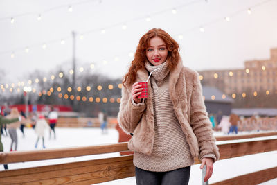 Portrait of smiling young woman standing in winter