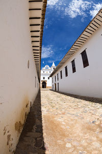 Road amidst buildings against sky