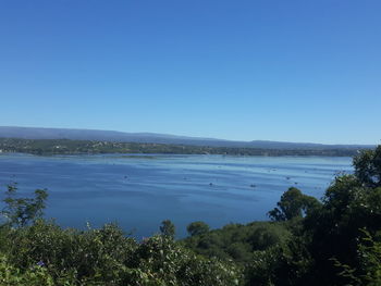 Scenic view of lake against clear blue sky