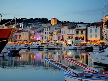 Boats moored at harbor against buildings in city