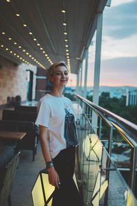 Portrait of woman standing on railing