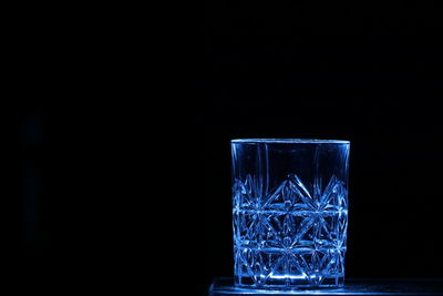 Close-up of glass on table against black background