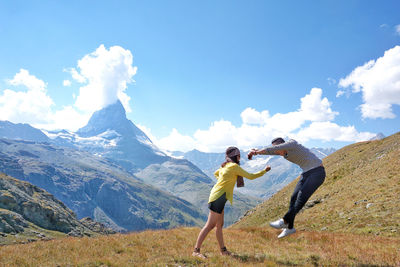 People on mountain against sky