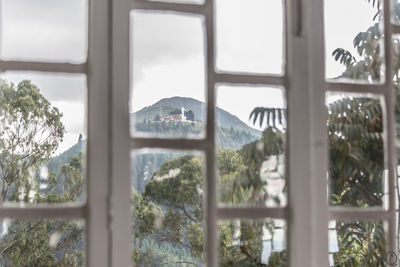 Scenic view of mountain against sky seen through window