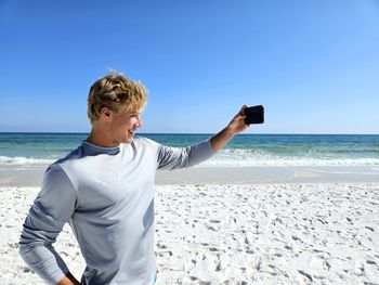 Side view of man photographing at beach