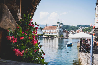 Scenic view of river by buildings against sky