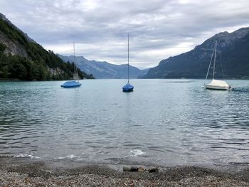 Sailboats in sea against sky