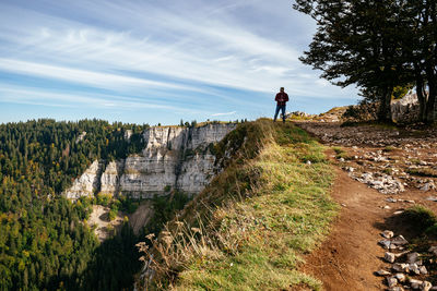 Man standing on rock against sky