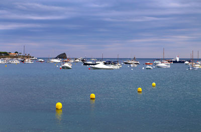 Sailboats in sea against sky