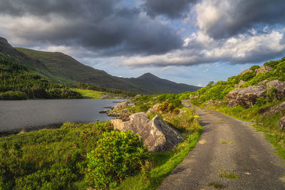 Scenic view of lake by mountains against sky