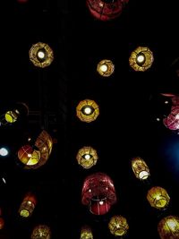 Low angle view of illuminated lights hanging at night