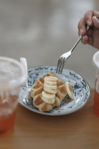 Cropped hand of woman having food