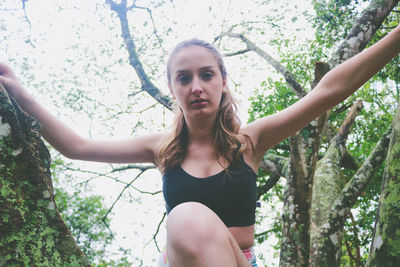 Low angle view of young woman on tree