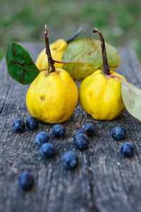 Close-up of quinces with blueberries on wooden table