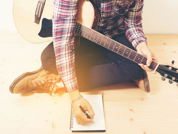 Low section of man playing guitar