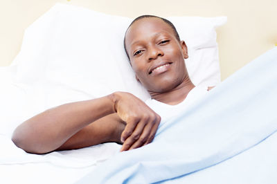 Portrait of smiling man lying on bed