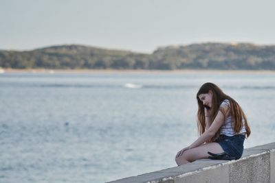 Young woman against clear sky