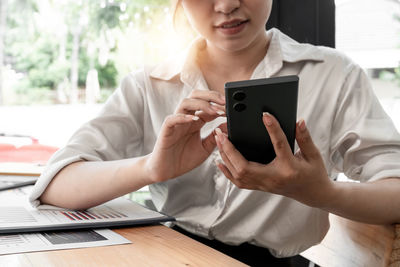 Midsection of woman using phone