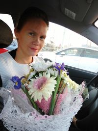 Close-up of woman holding flowers in vase