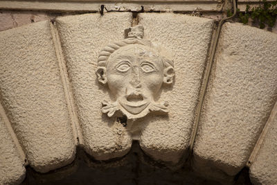 Close-up of old statue against wall