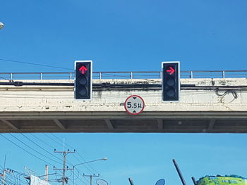 Low angle view of road signs against blue sky