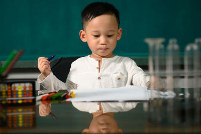 Cute boy looking at camera while standing on table