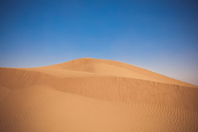 Scenic view of desert against blue sky