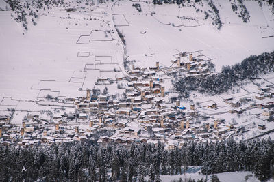 High angle view of snow covered trees and buildings