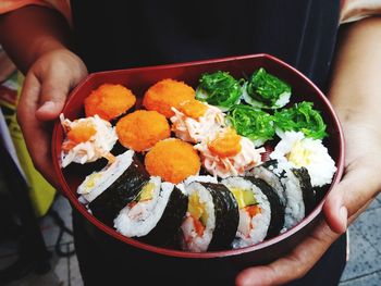 Midsection of person holding sushi