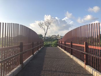 Empty footpath amidst buildings against sky