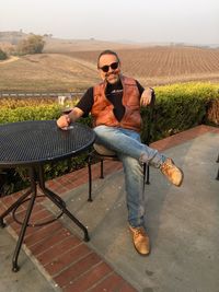 Portrait of smiling man sitting on chair outdoors