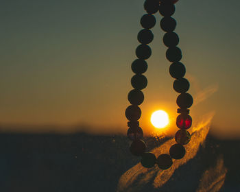 Illuminated lights and armband against sky during sunset