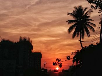 Silhouette palm trees against sky at dusk