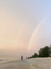 Scenic view of rainbow over sea against sky