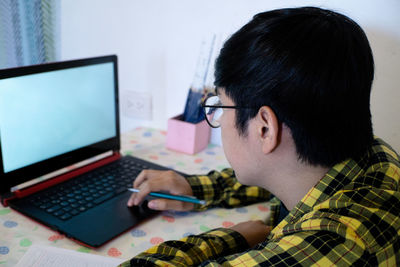 Man using mobile phone while sitting on table